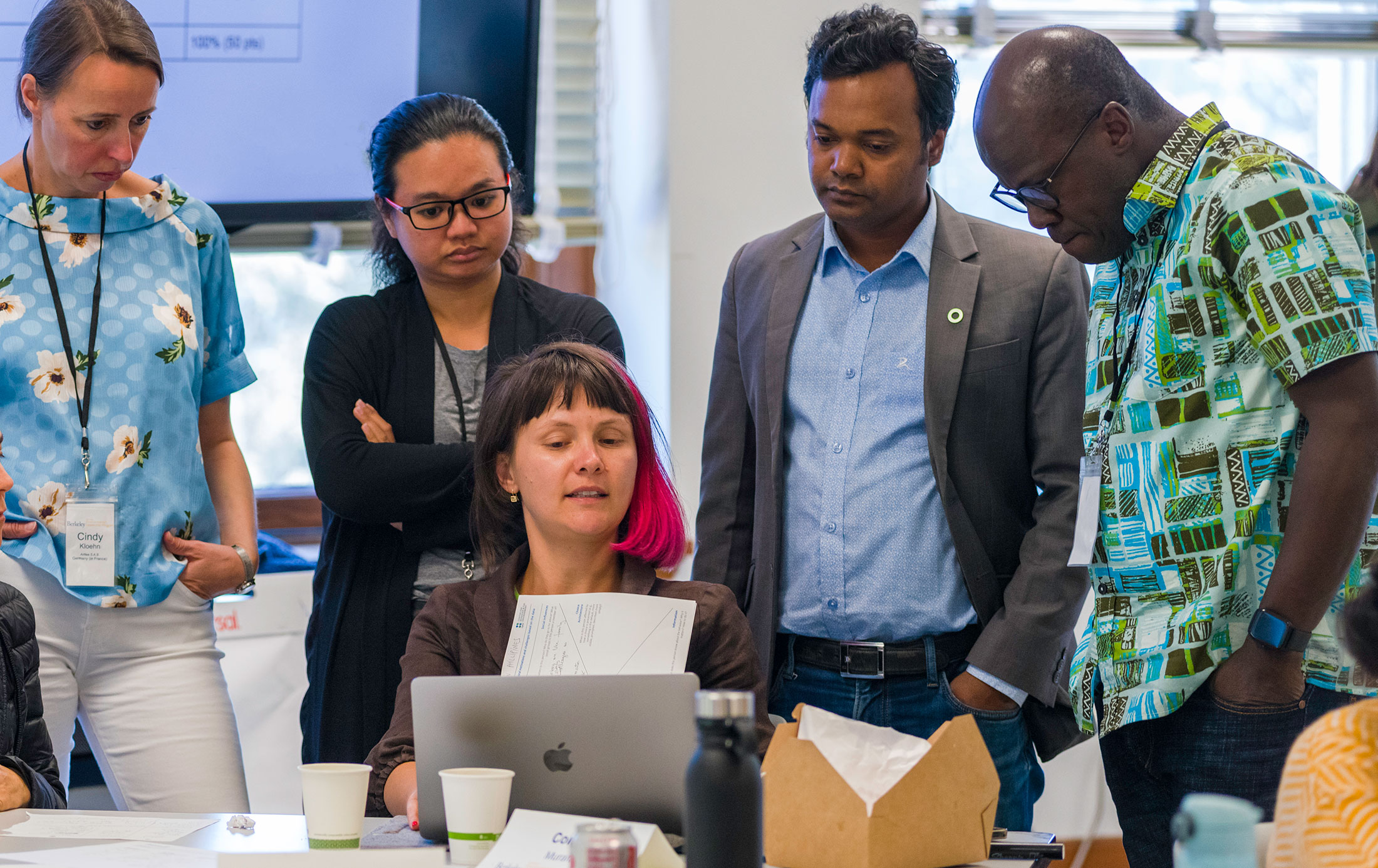 a group of people looking at a laptop