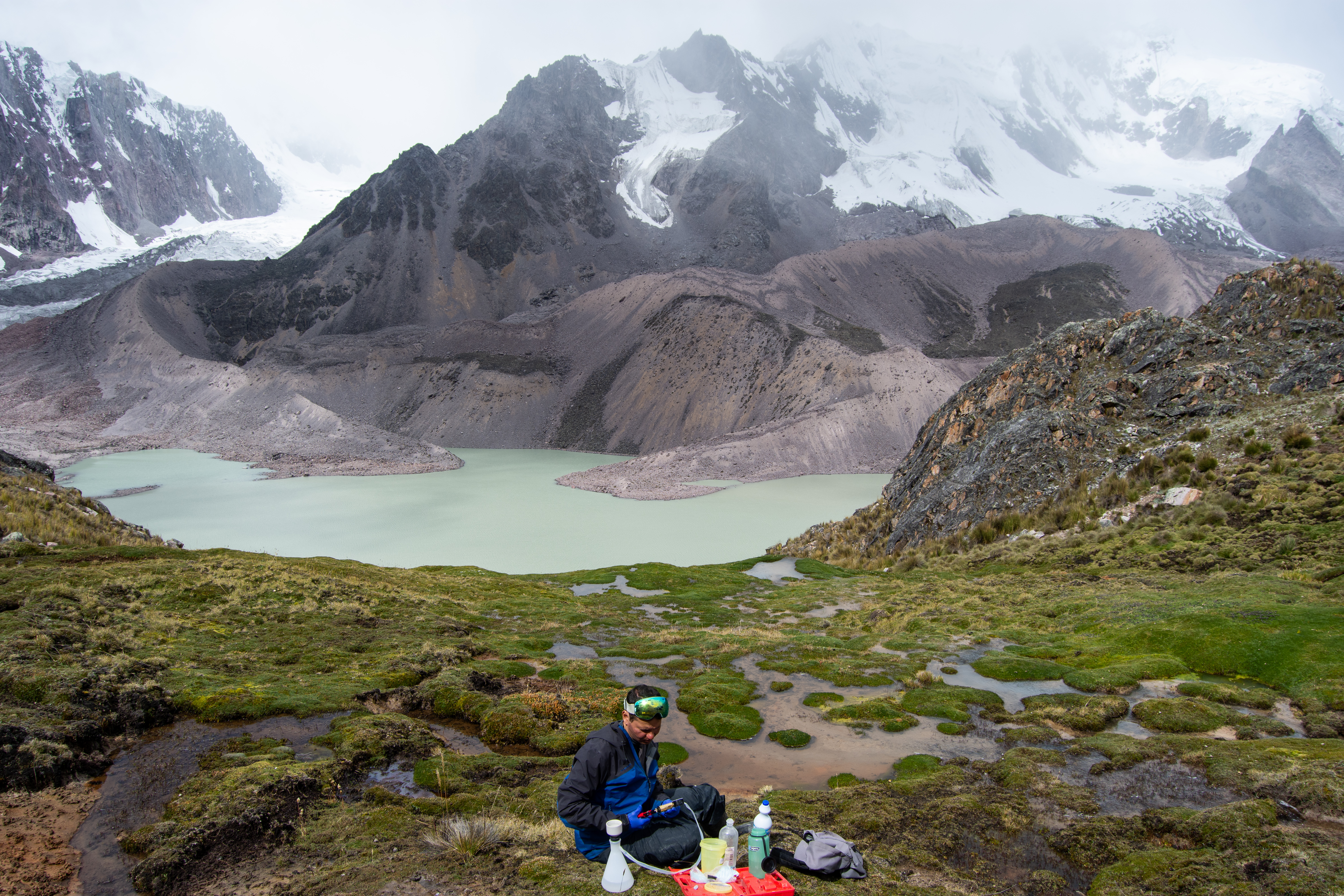 Person sitting at a camp near a lake.