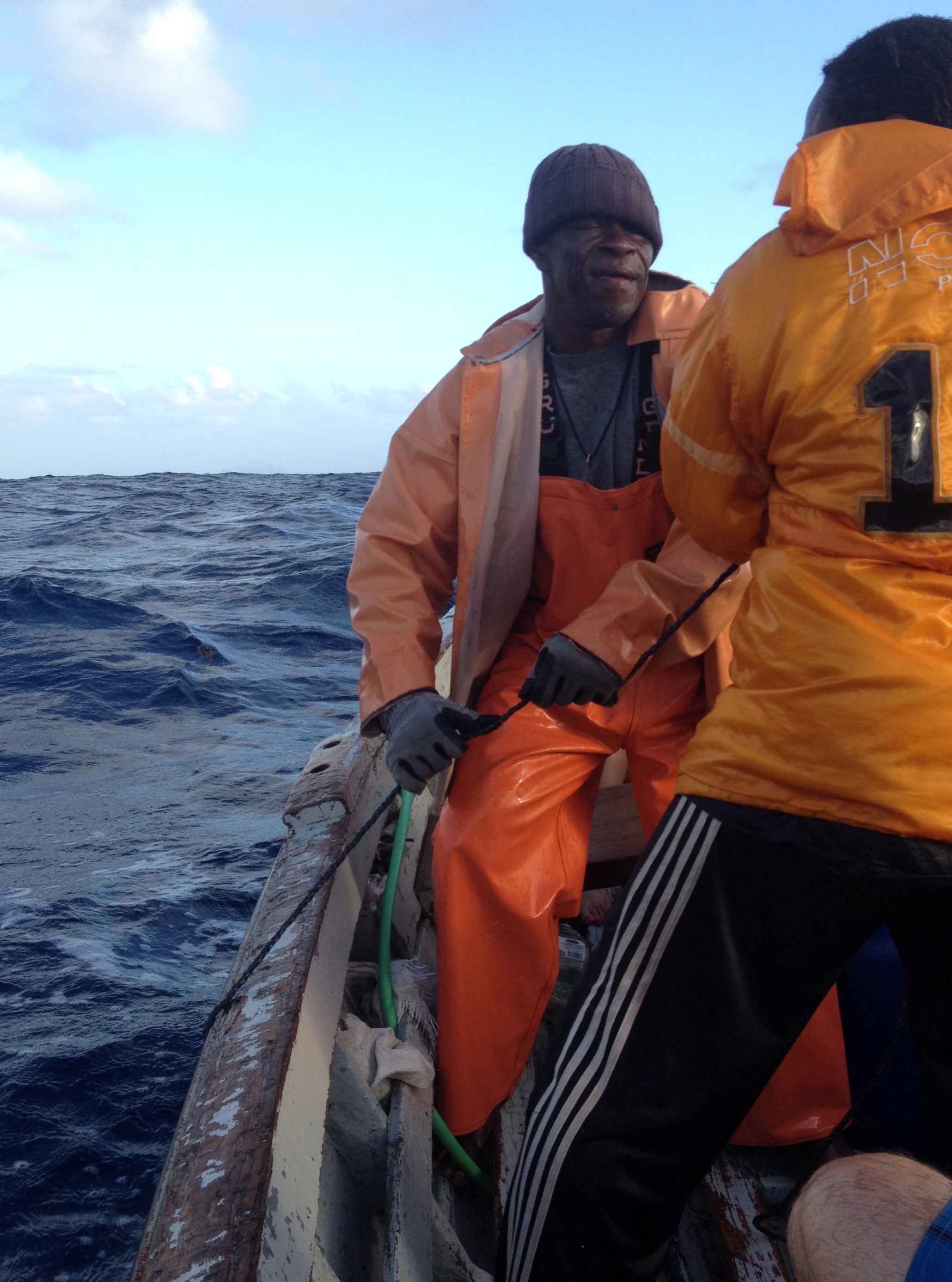 A man pilots a boat over blue Caribbean waters
