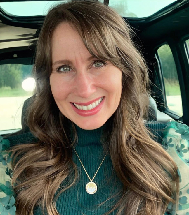 A photo of a woman smiling in a car.