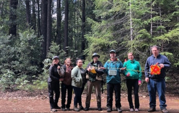 a group of people standing in a forest