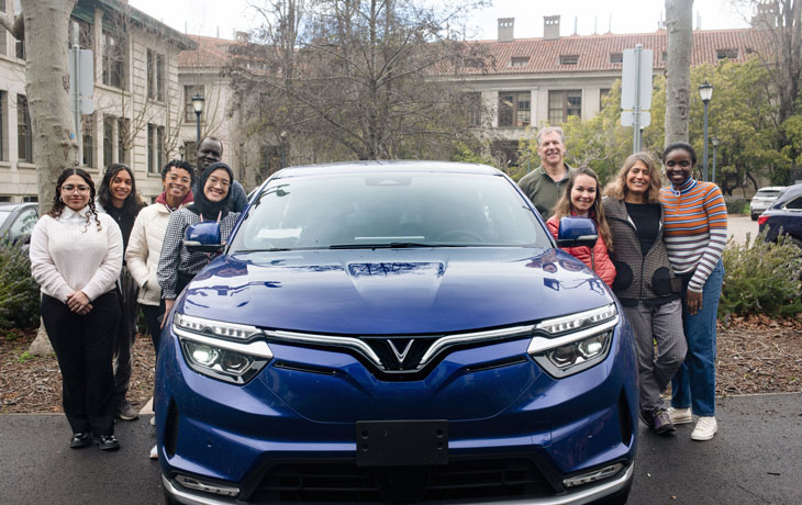 Student surrounding blue car