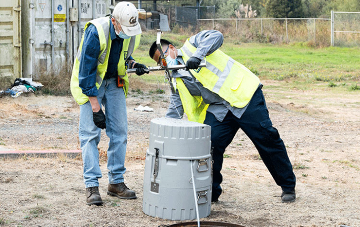 Two people over a manhole