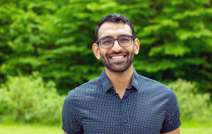 Dhruv Patel standing in front of a Green background.