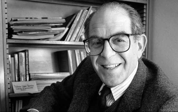 Headshot of Gene Rochlin as his desk
