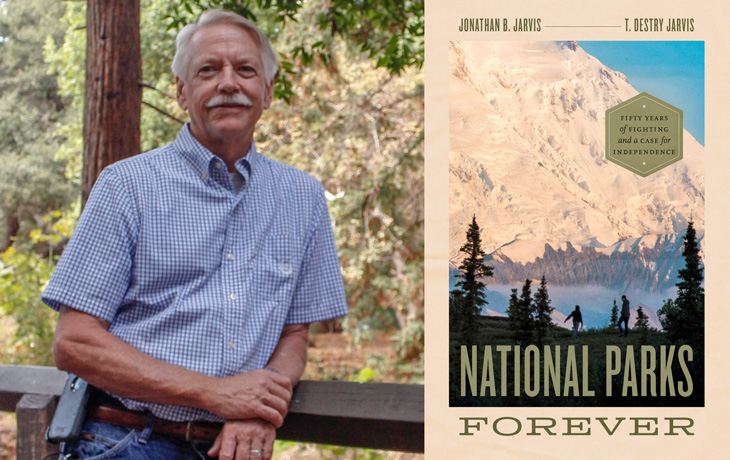 Jon Jarvis posing next to a large book cover display