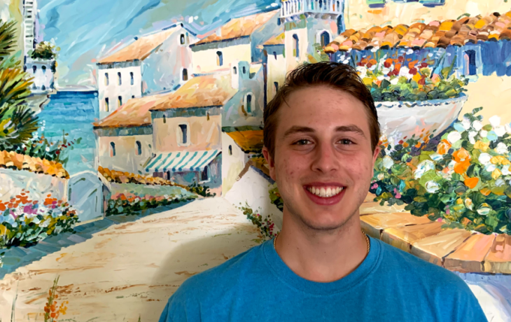 Michael Spencer standing in front of a painted background.
