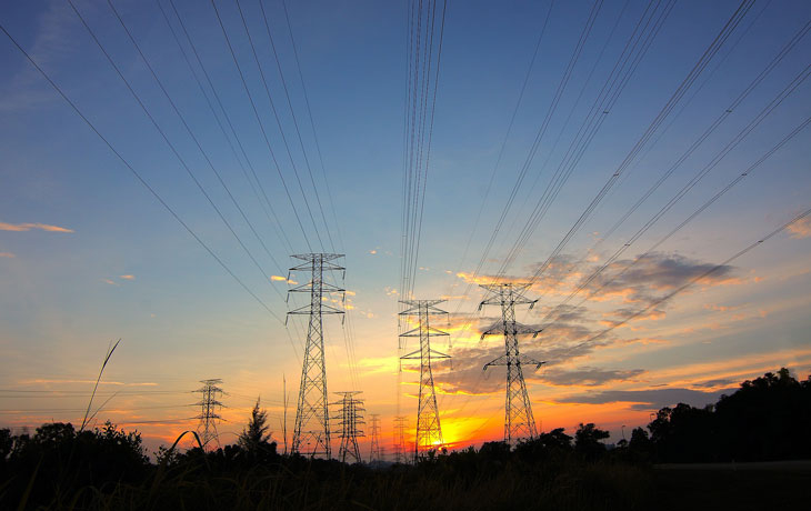 Large powerline towers against a sunset