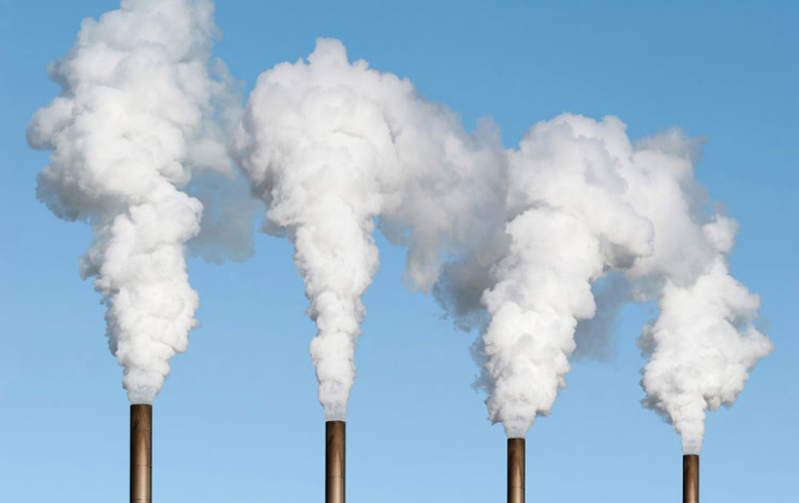 four smoke stacks against a blue sky