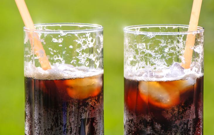 Two glasses with ice and unidentifiable soda in them.