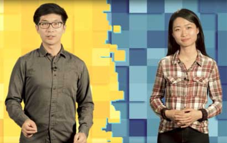 Two students stand in front of a green and blue screen