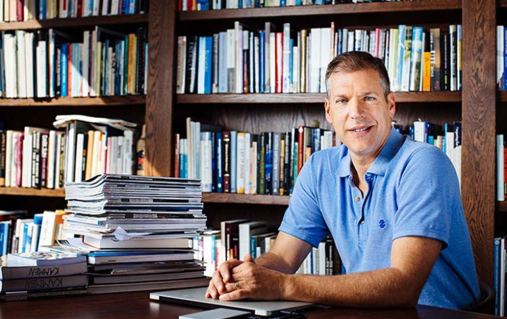 A headshot of Daniel Kammen in a library.