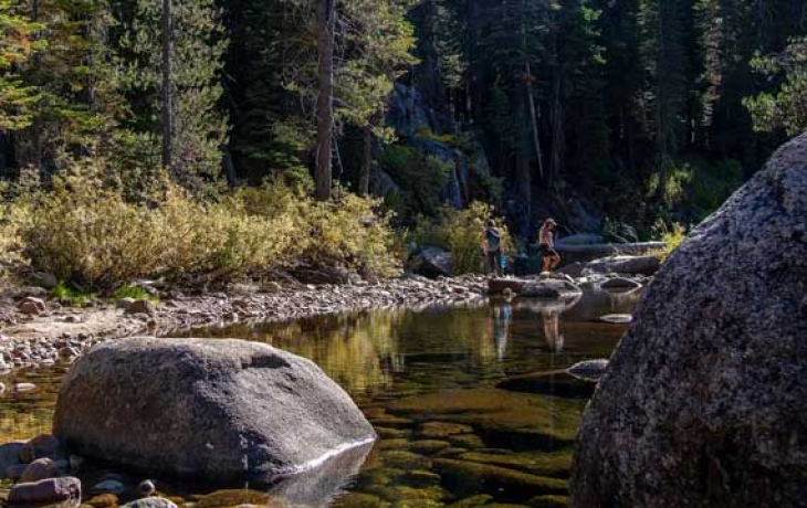 A woman walks across a river