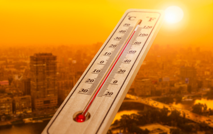 Thermometer in front of cityscape 
