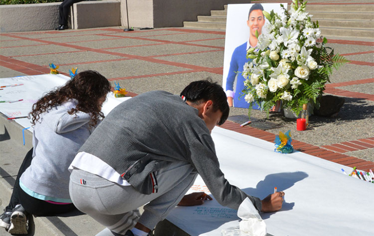 Students sign a commemorative poster for Nicolas Leslie