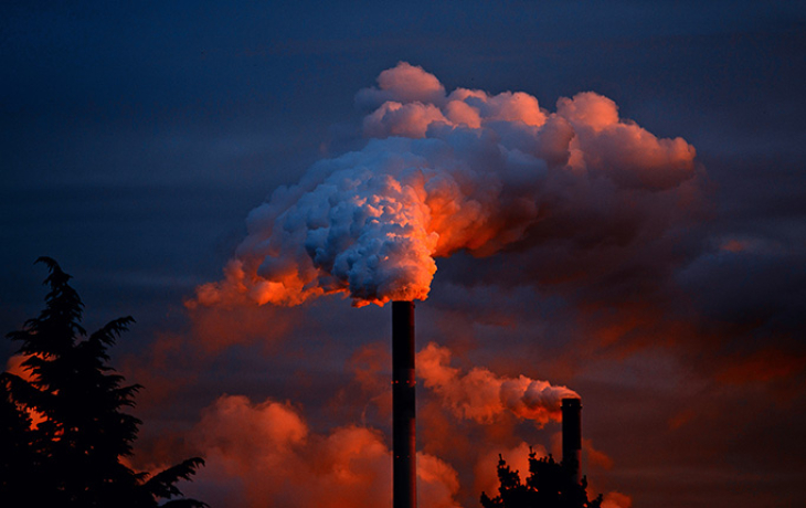 Smokestack emitting gases against a night skyline